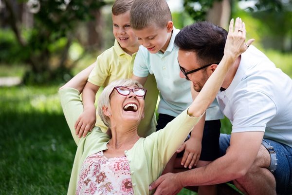 Happy Family Playing And Enjoying Picnic With Children Outside