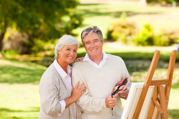 Retired Couple Painting In The Park